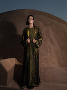 Onyx Serenade fringed black lace Moroccan kaftan over a mustard-gold dress, full-length view